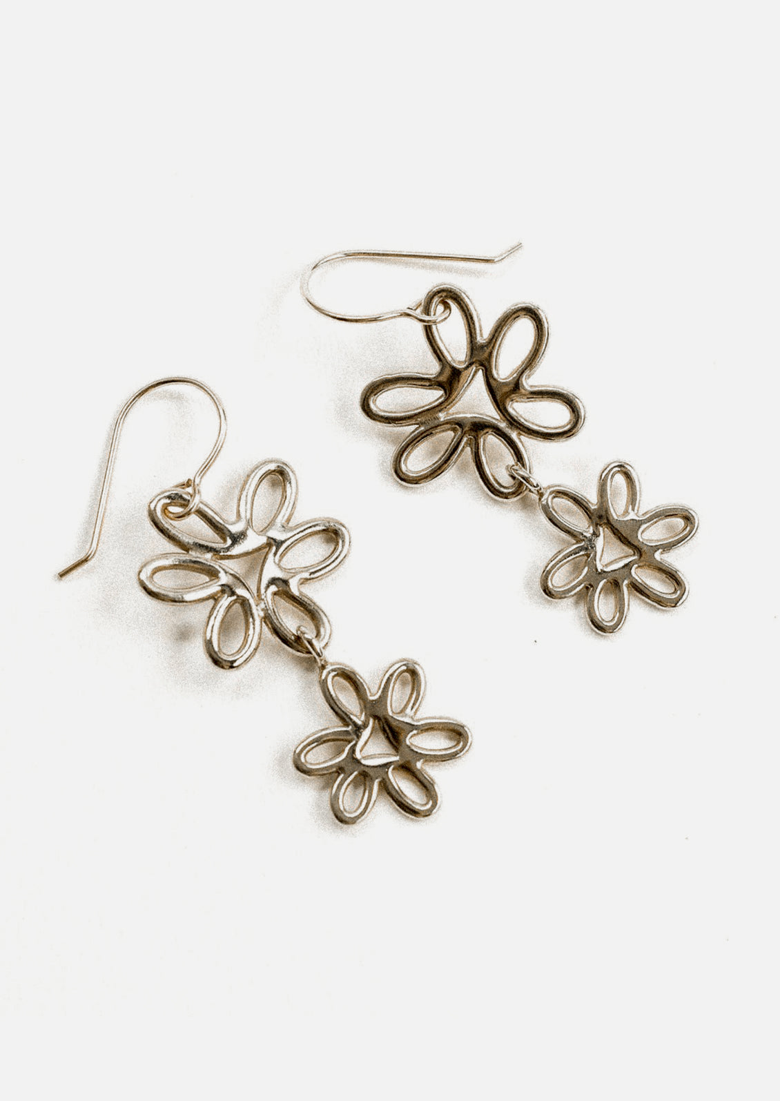 A pair of sterling silver earrings with connected double flower shape.