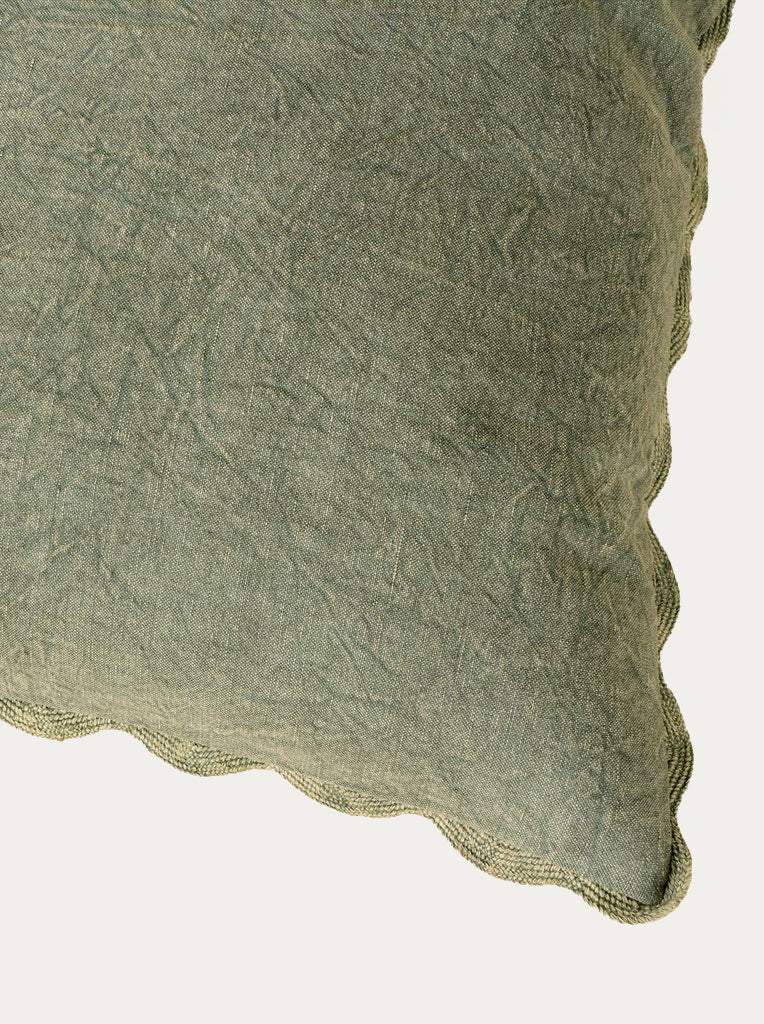 Close-up of a green textured fabric pillow on a white background