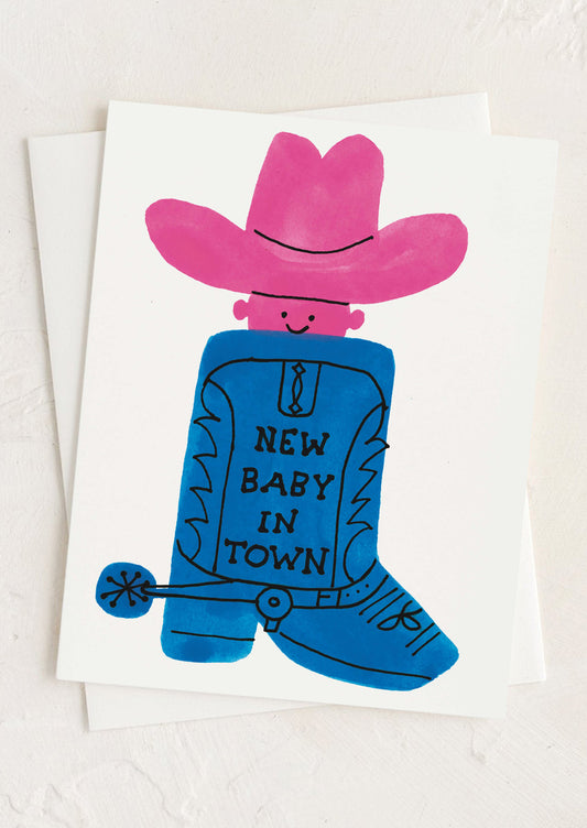 Card with a blue boot and pink cowboy hat, featuring 'New Baby in Town' text on a white background.