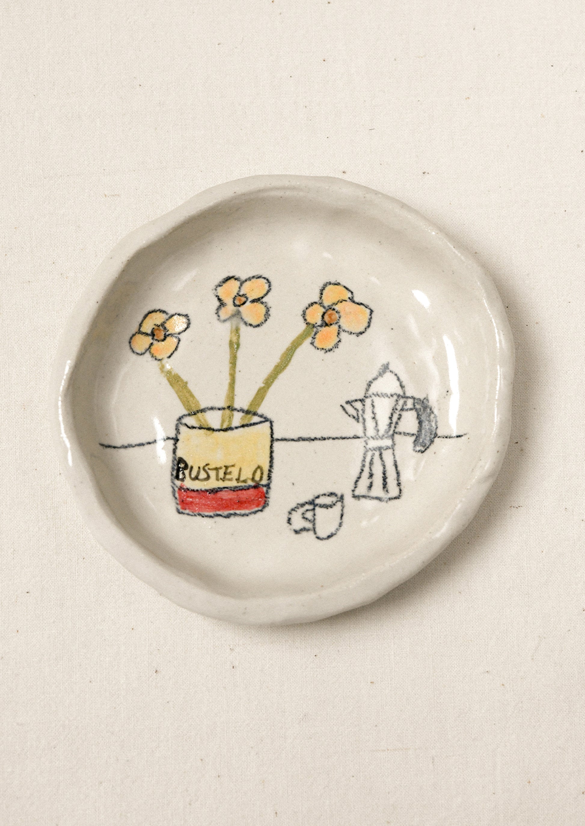 A small ceramic dish with an illustration of coffee and flowers.