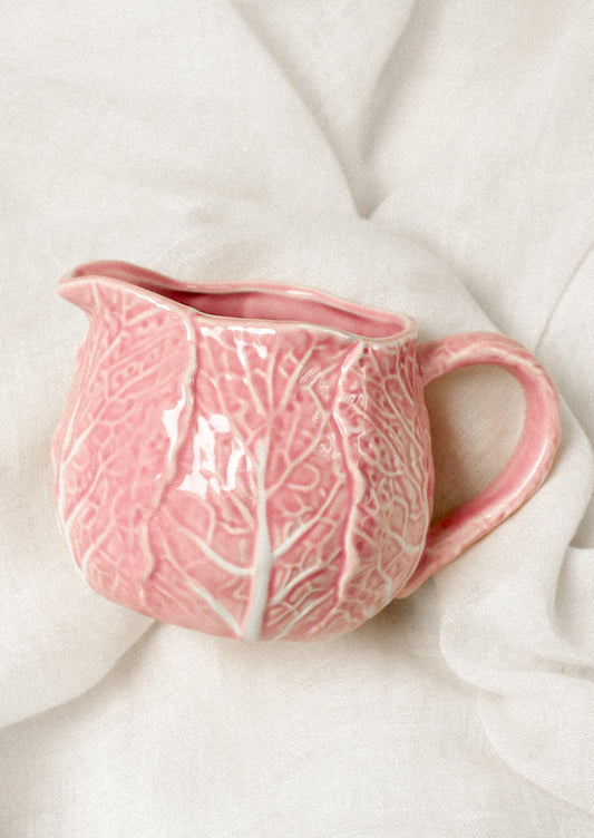 Pink ceramic creamer with textured cabbage design.