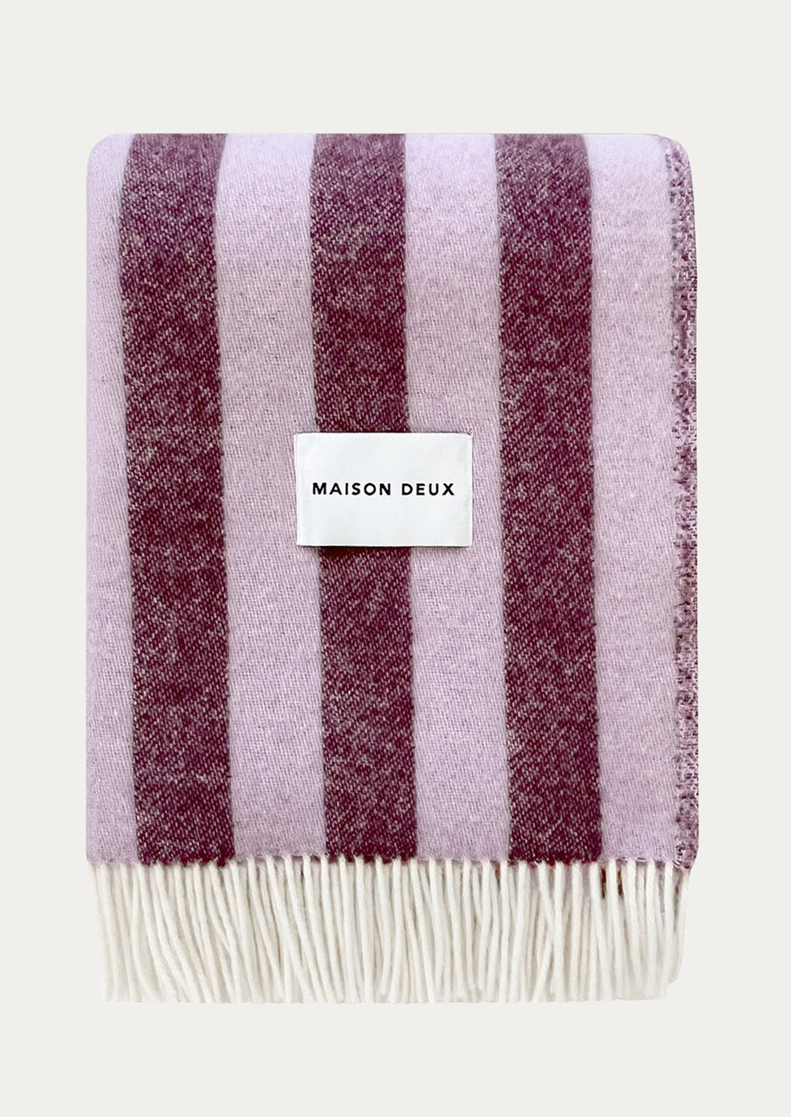 Striped blanket in light purple and burgundy with 'Maison Deux' label.