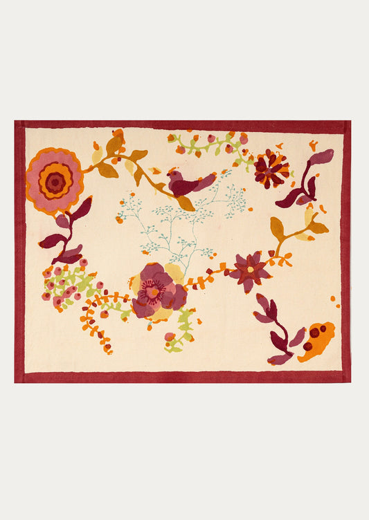 Decorative placemat with floral and bird pattern on a beige background