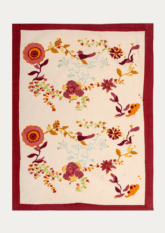 Decorative tea towel with floral and bird pattern on a beige background