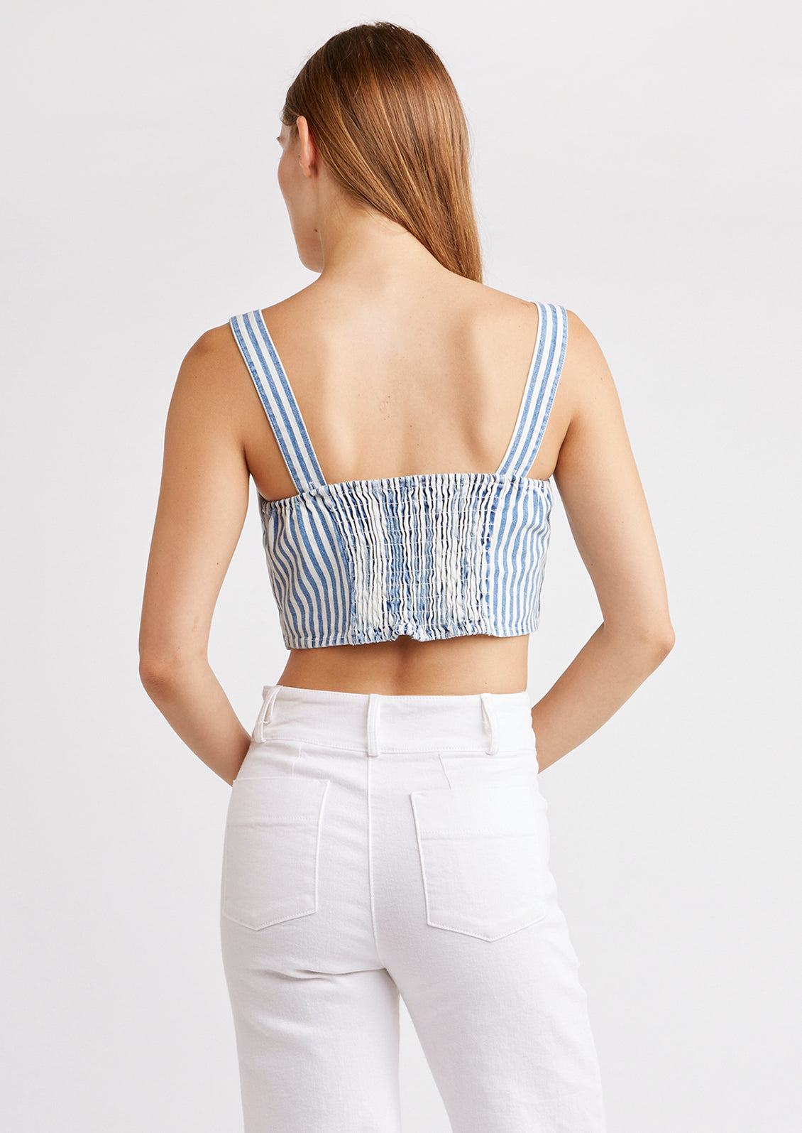 A woman wearing a square neck crop top with smocked elastic back.
