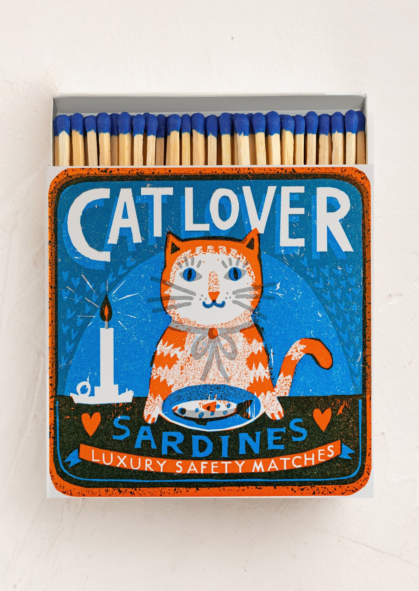 A large square box of matches with cat with sardines design on box, matches have blue tips.