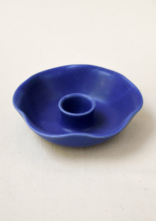 A porcelain candle holder with ruffled shape in cobalt blue.