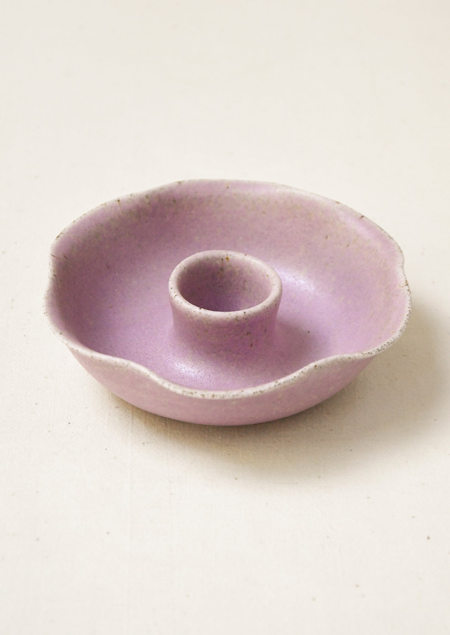 A porcelain candle holder with ruffled shape in lavender.