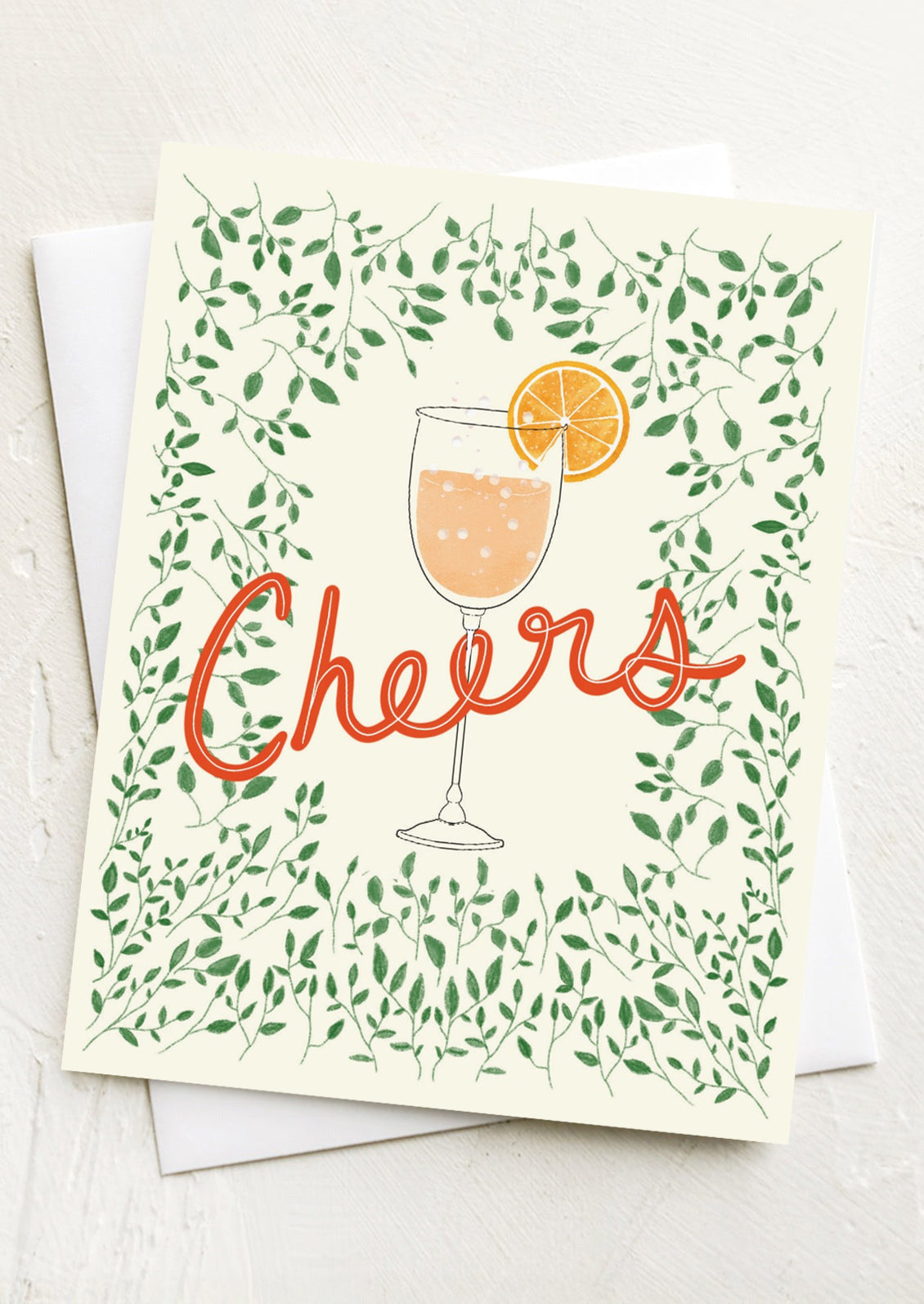 A greeting card with image of spritz cocktail glass, text reads "Cheers".