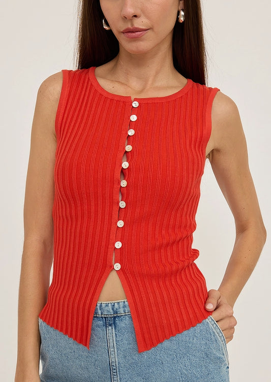 A person wearing a red sleeveless top with multi button front.