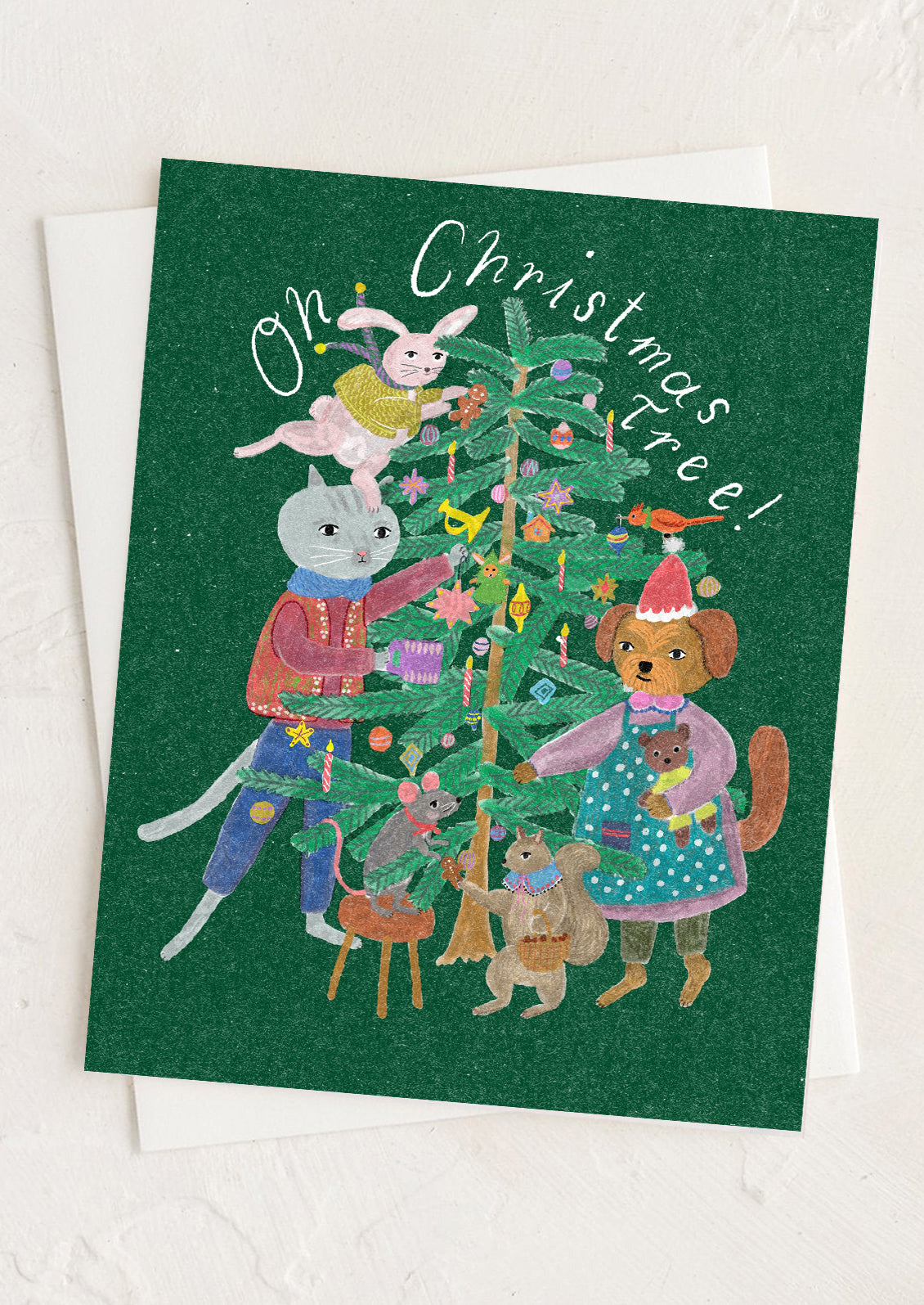 A greeting card with illustration of animals gathering around a christmas tree.