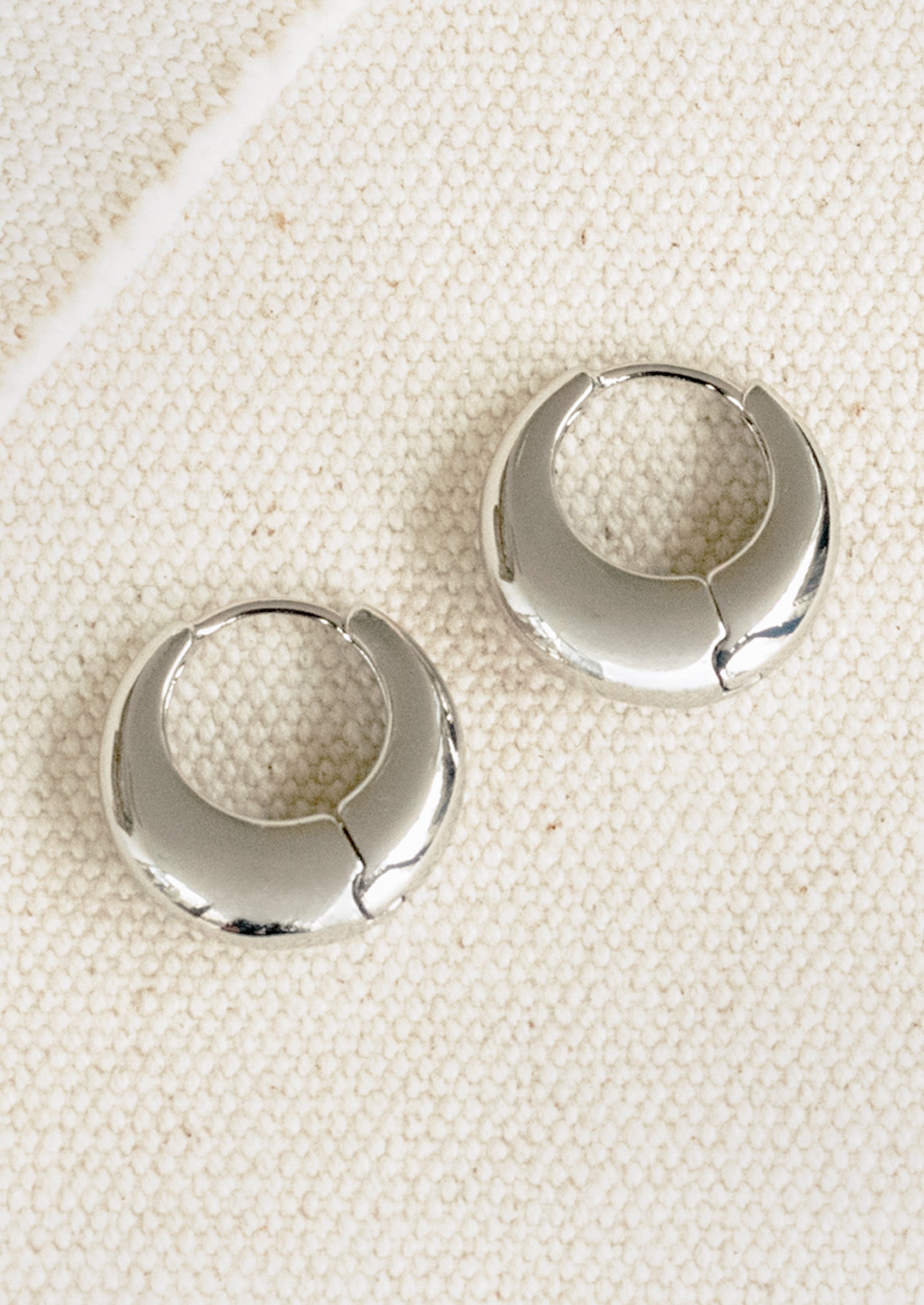 A pair of chubby silver hoop earrings.
