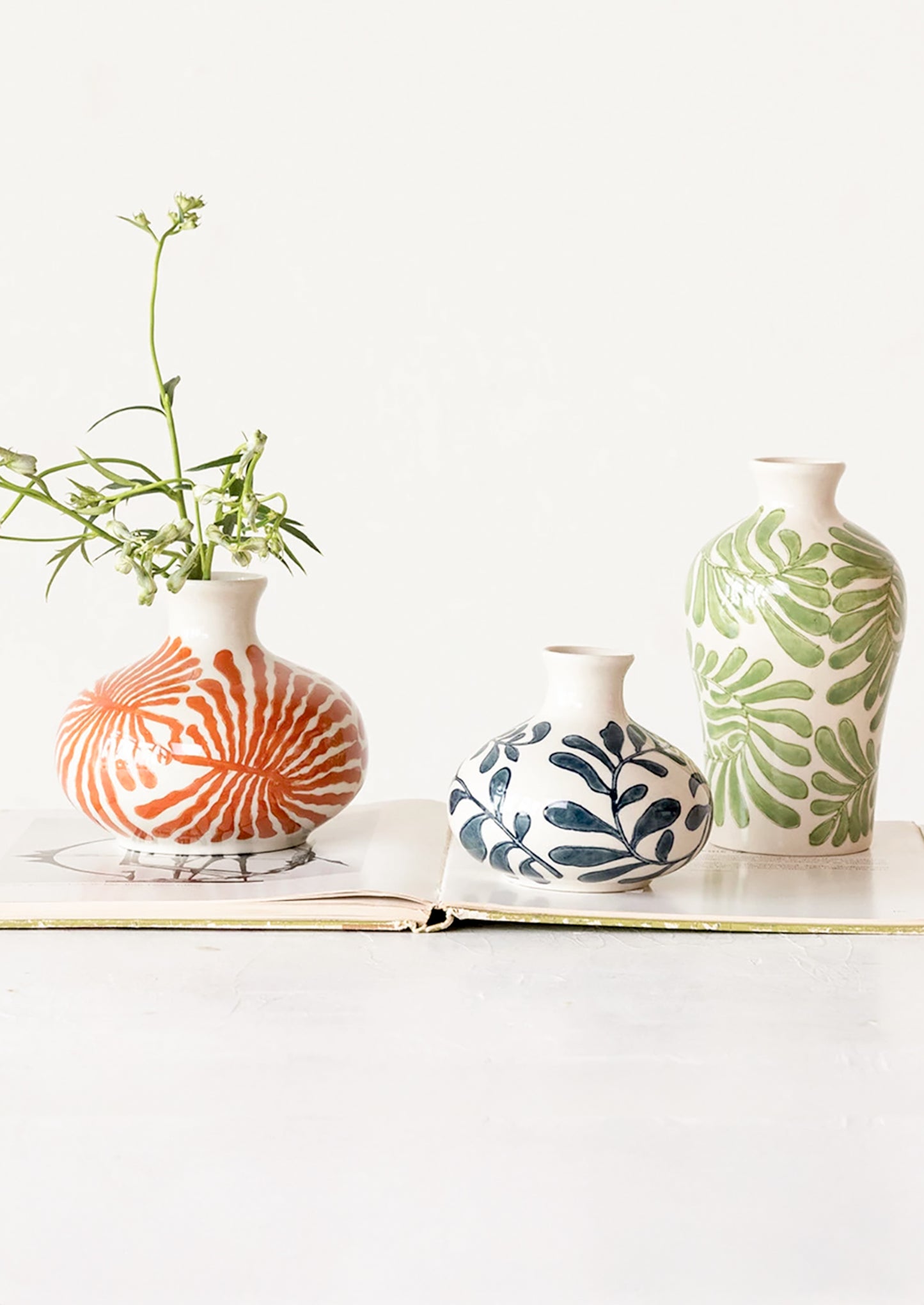 Vases in different shapes and colors with seaweed/leaf patterns.