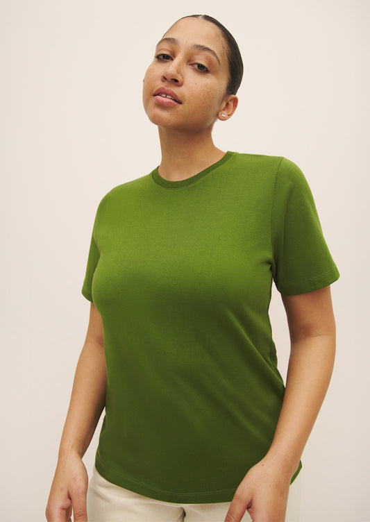 A woman wearing a knit cotton jersey short sleeve tee in vibrant green color.