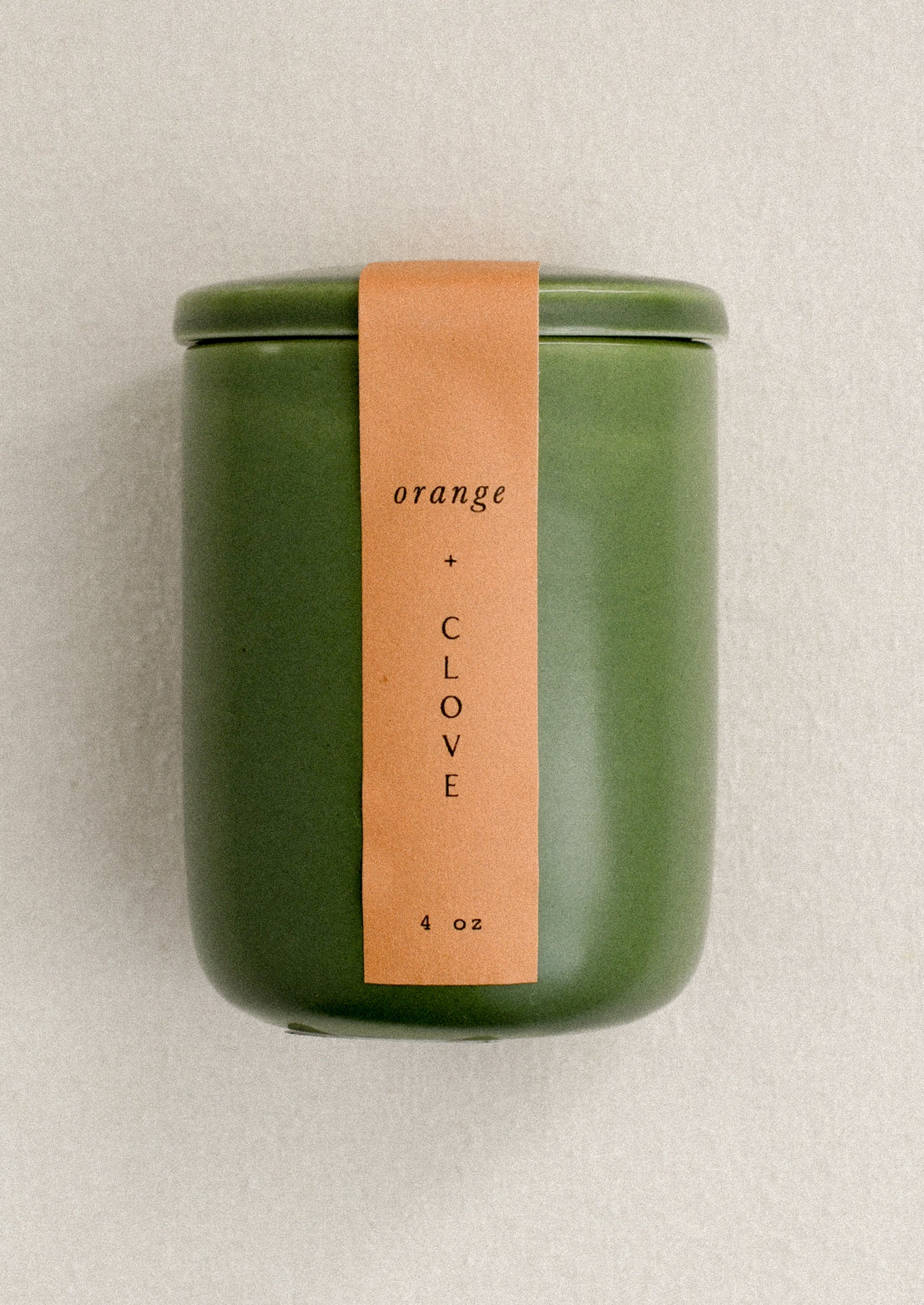 Green candle jar with an orange label