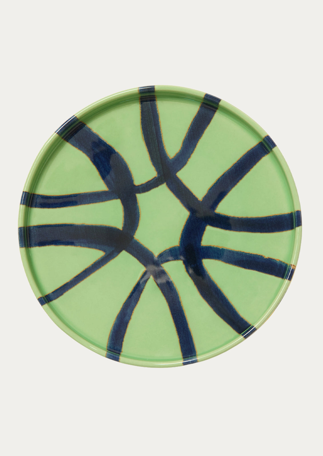 A ceramic side plate with an abstract design in a clover green color.