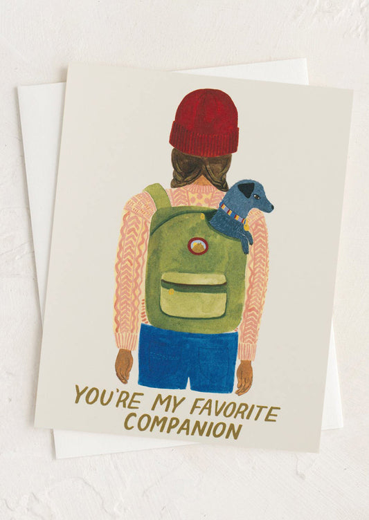 Card with illustration of person wearing a green backpack and red beanie, holding a blue dog, with text 'You're my favorite companion' on a white background.