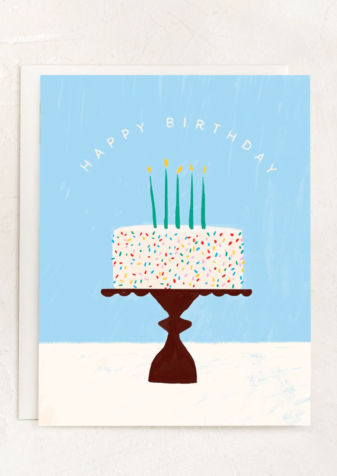 A greeting card with illustration of confetti cake, text reads 'Happy Birthday'.