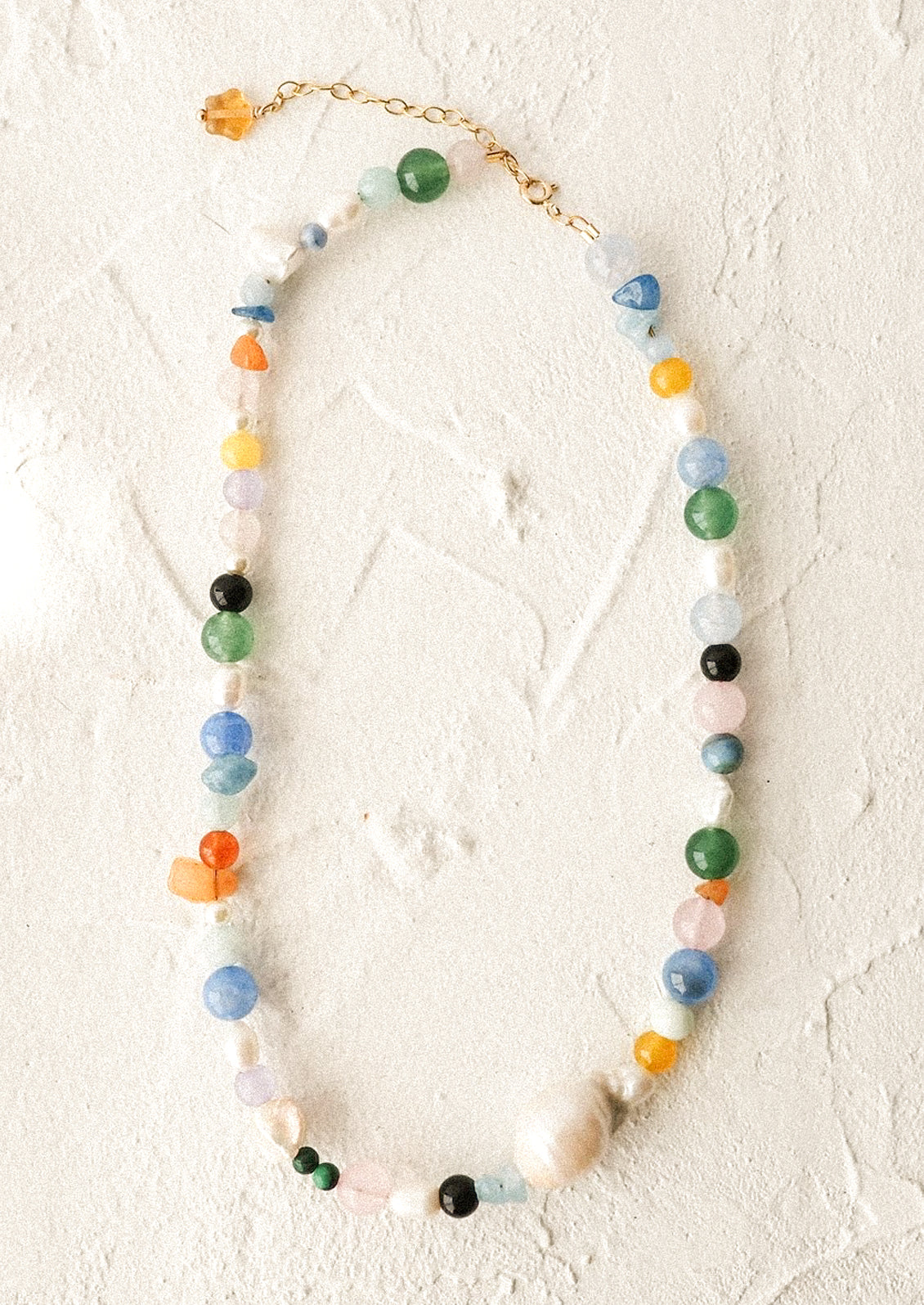 A  necklace with colorful natural gemstones and baroque pearls.