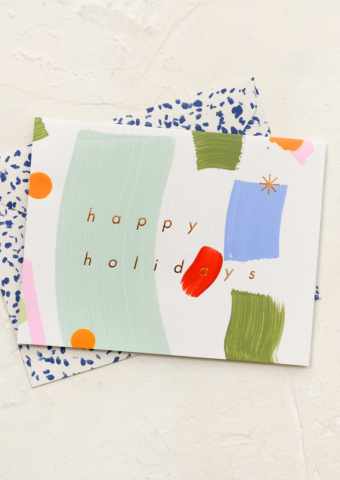 A hand painted card with text reading "Happy Holidays".