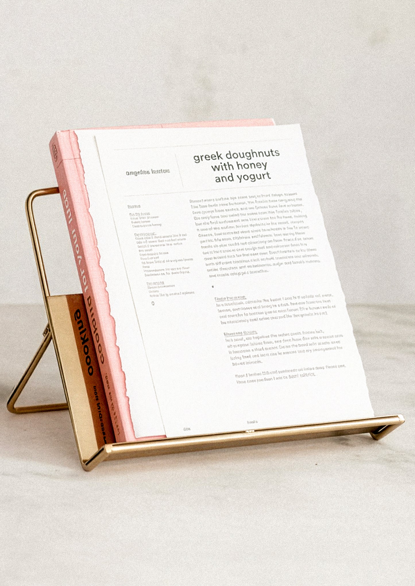 A folding book stand in gold-tone metal.