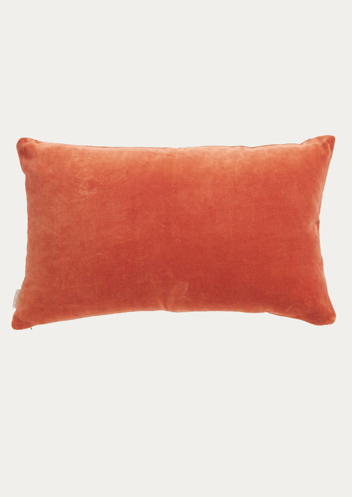 A rectangular lumbar throw pillow in a textured rust-orange velvet fabric.