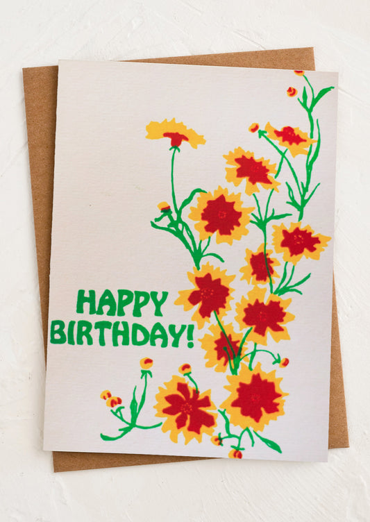 A greeting card with printed image of coreopsis flowers, text reads "Happy Birthday!".