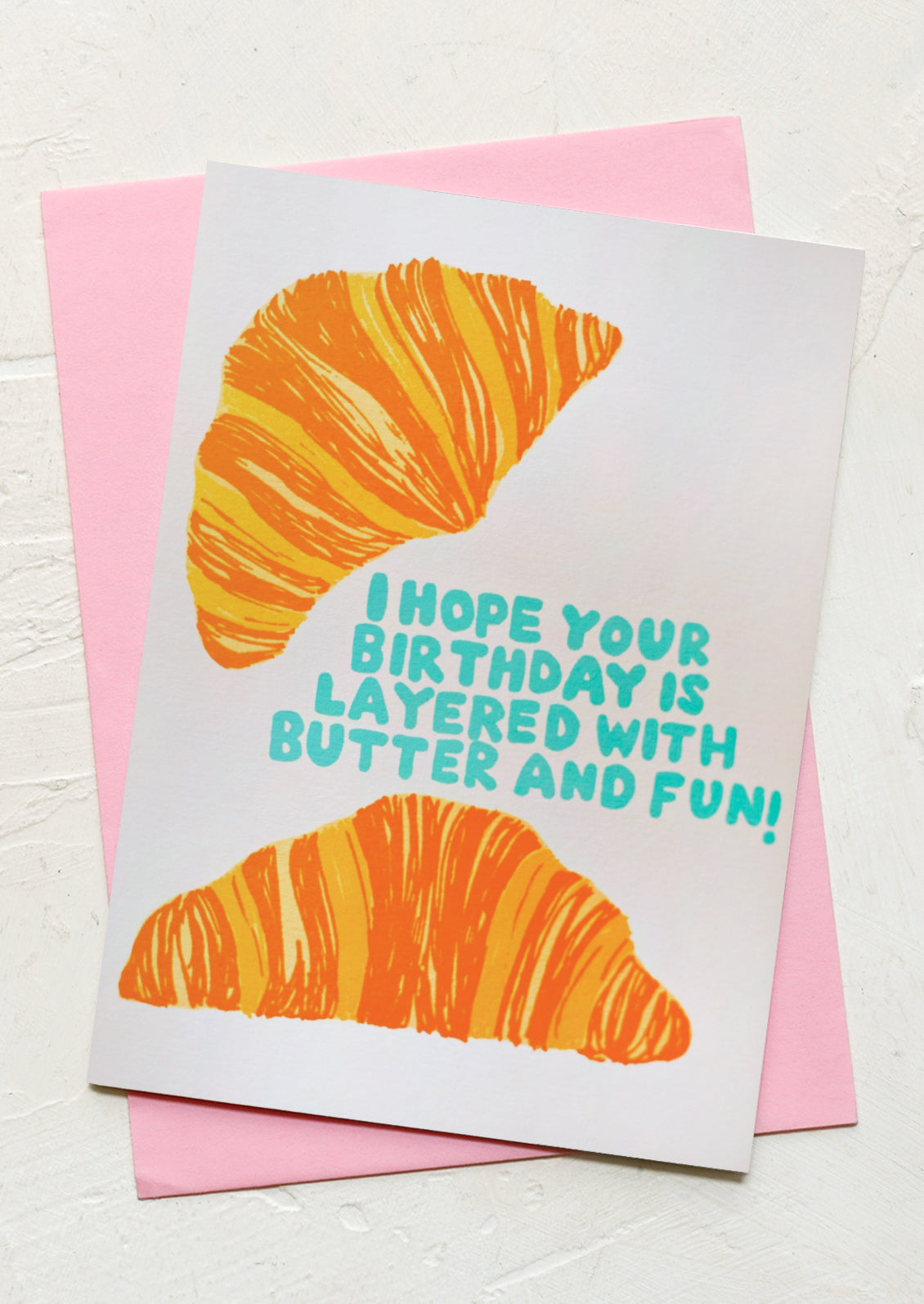 A croissant print card, text reads "I hope your birthday is layered with butter and fun!".