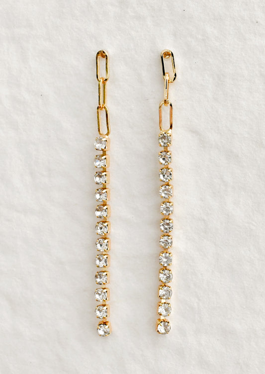 A pair of dainty earrings with paperclip chain top followed by tennis style crystals.