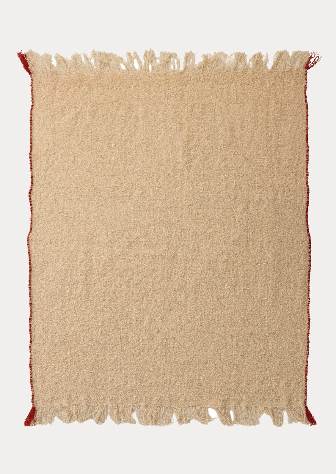 A square beige woven rug with fringed edges and small red corner accents, shown flat against a light gray background.