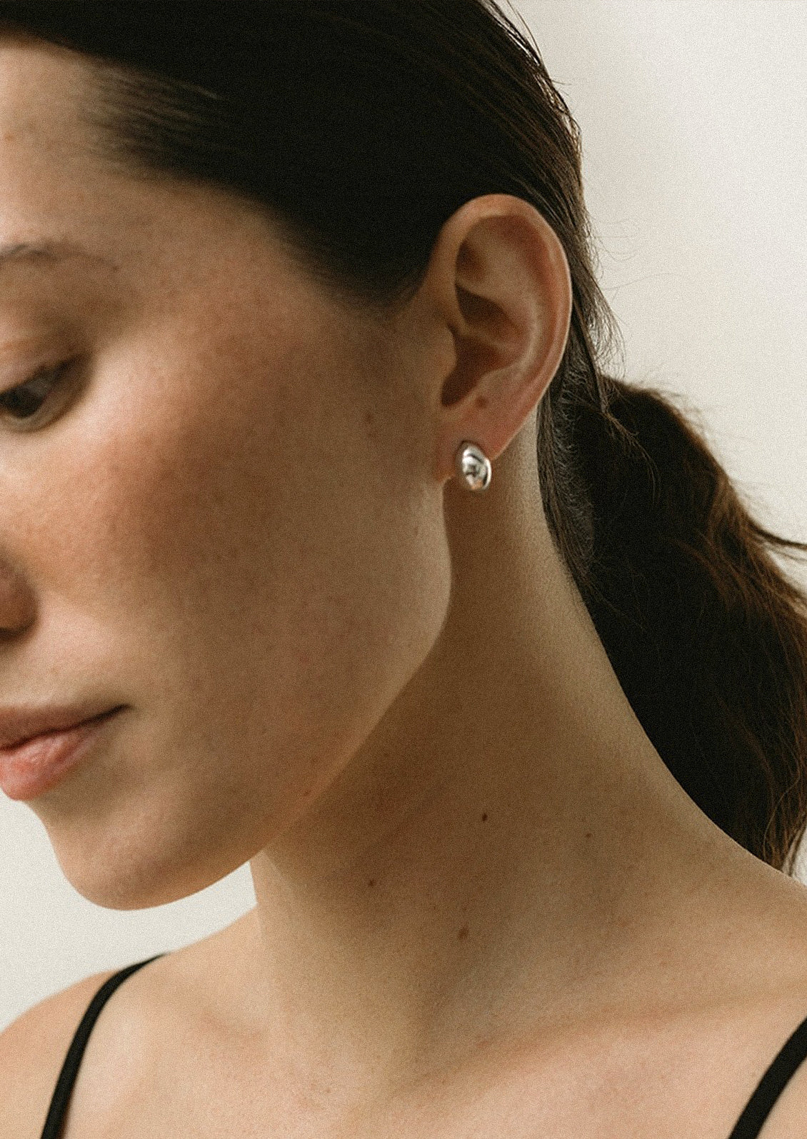 A pair of sterling silver curved huggie earrings.