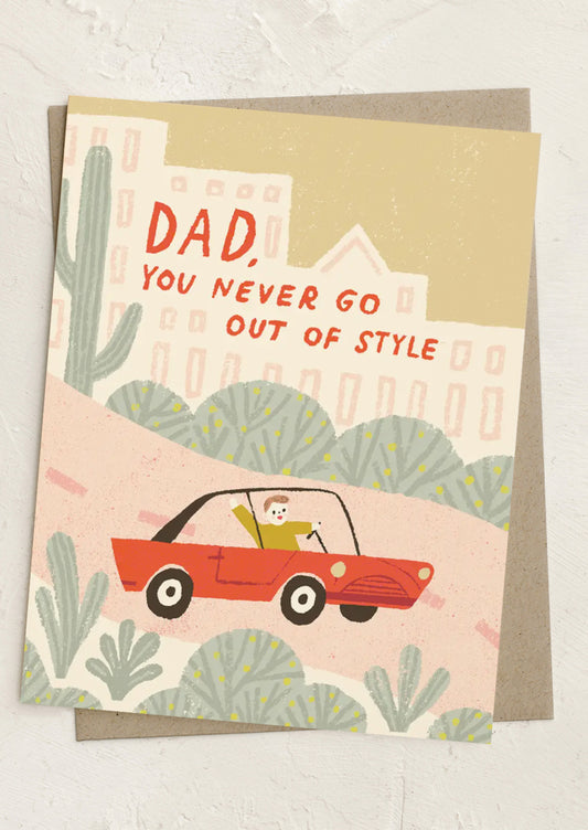 Greeting card with illustration of a man in a red car and text 'Dad, you never go out of style' on a beige background.