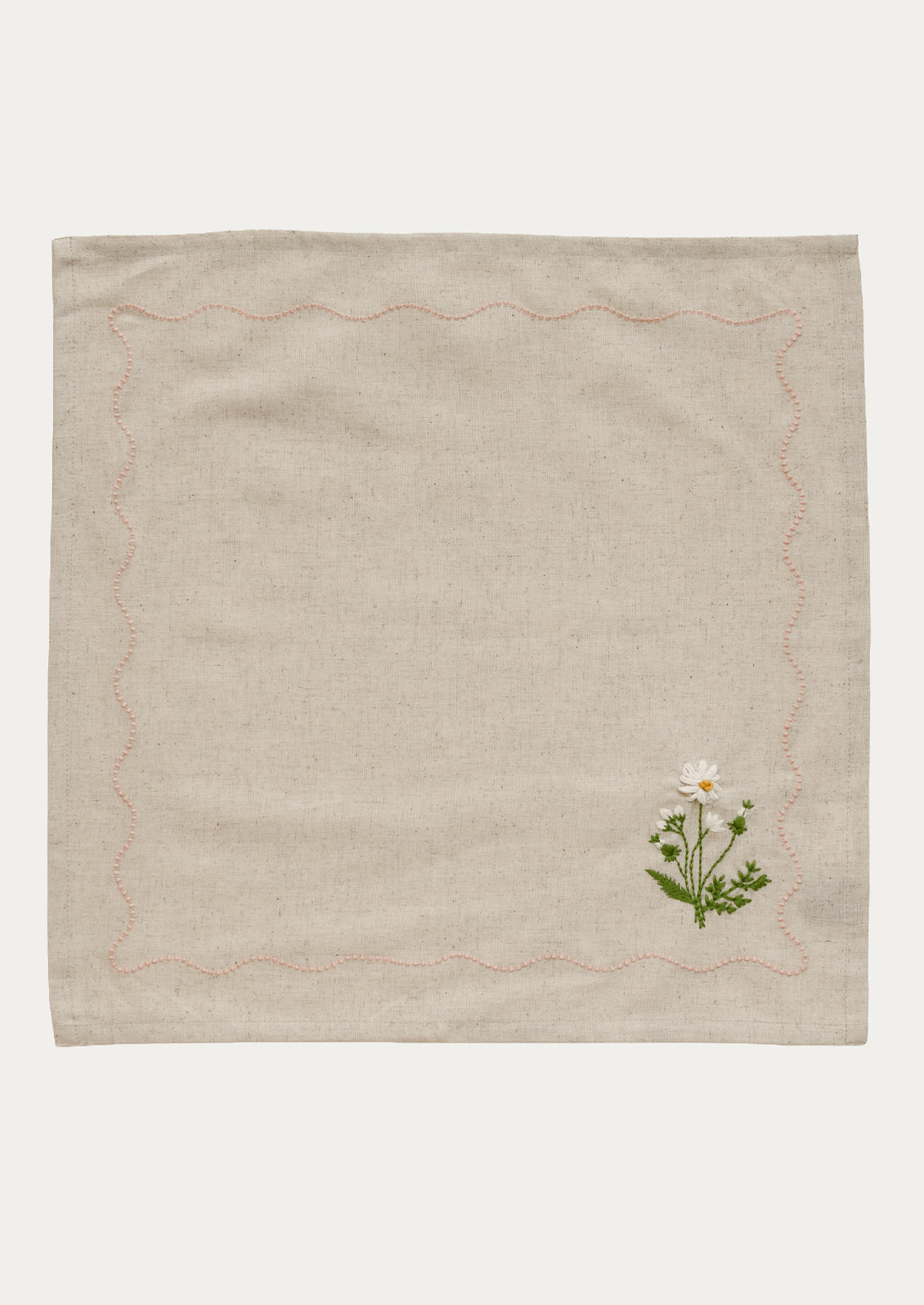 Beige fabric with embroidered floral design on a white background