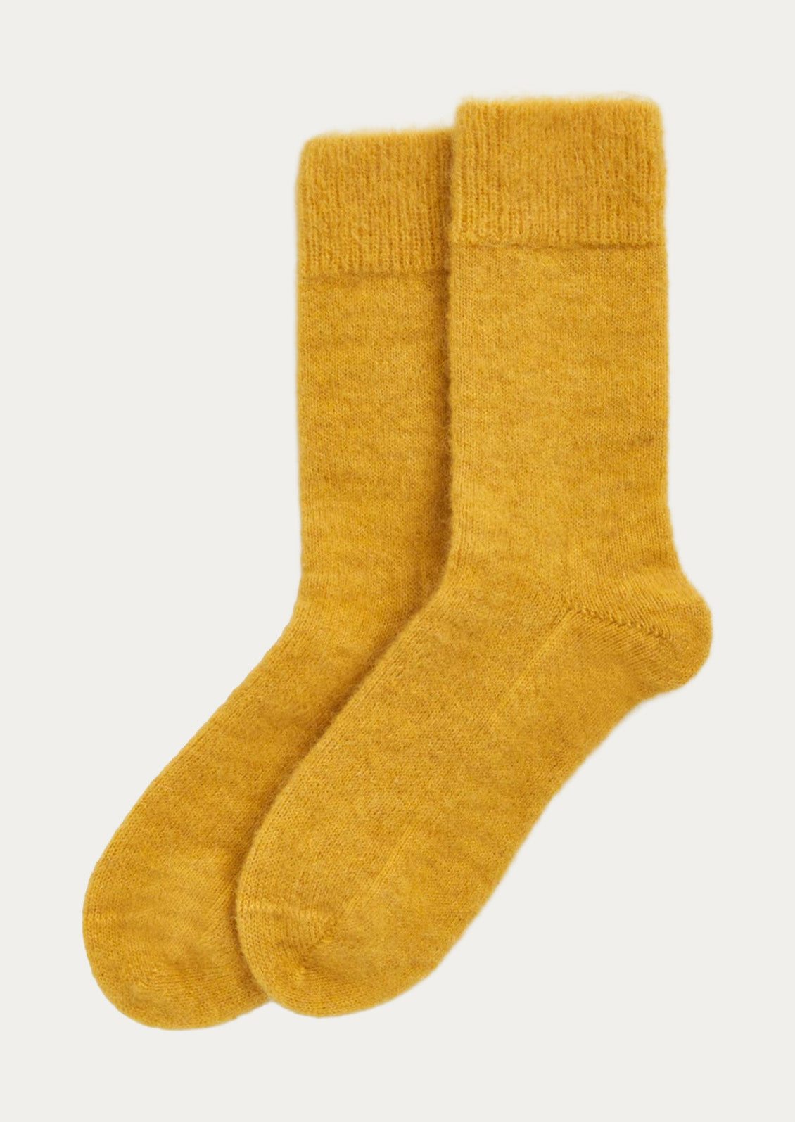 A pair of textured alpaca blend, calf-length socks in bright yellow.