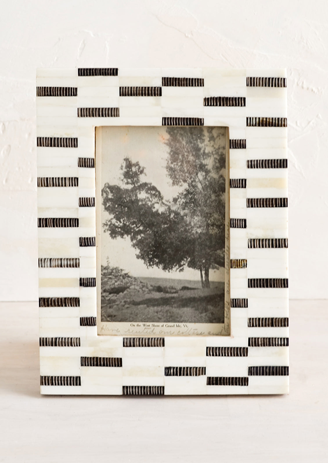 A tabletop picture frame in black and white dashes pattern.