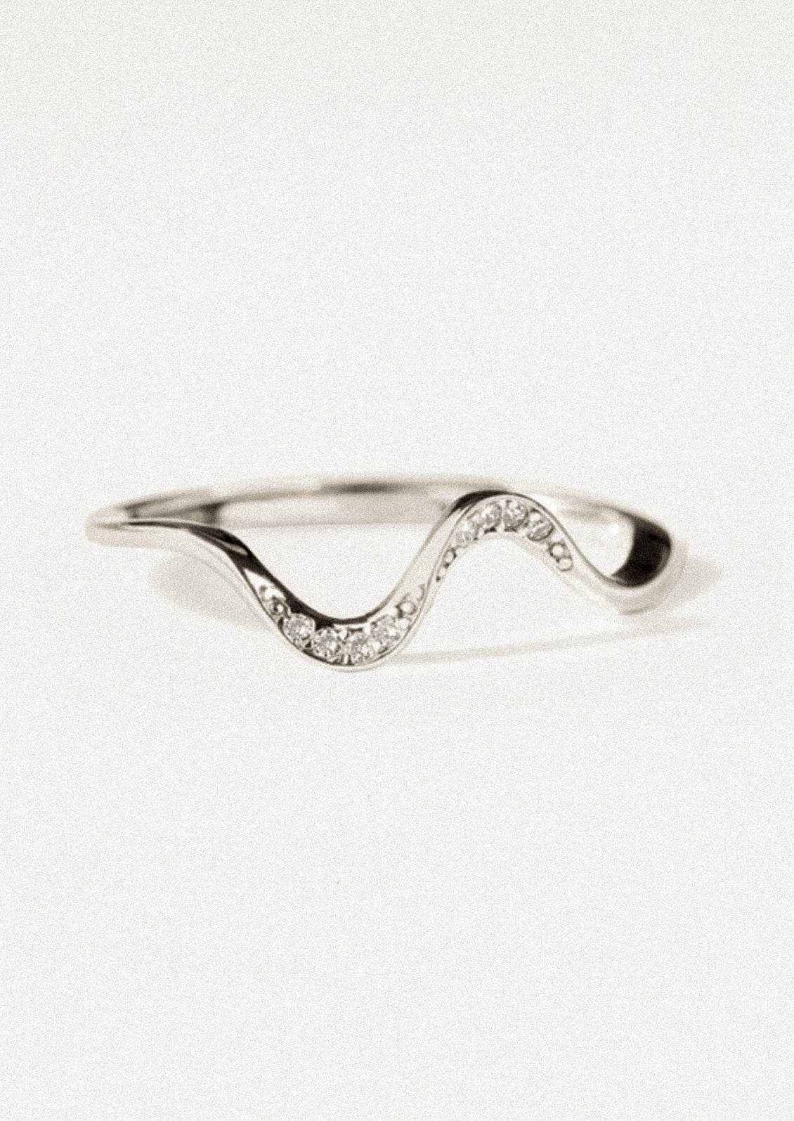 A wavy silver ring with crystal detailing.