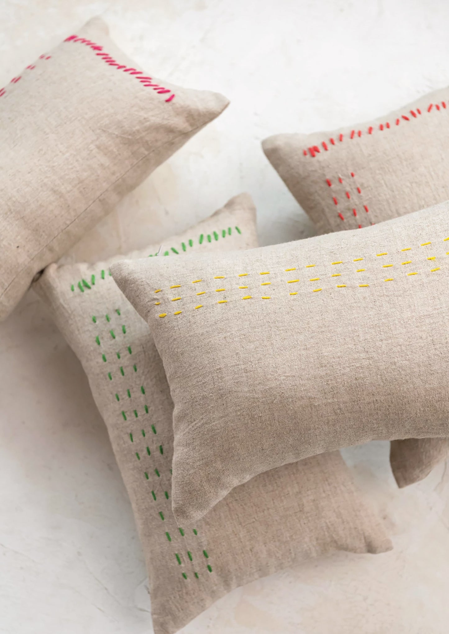 Linen lumbar pillows in natural linen with assorted color stitching detail.