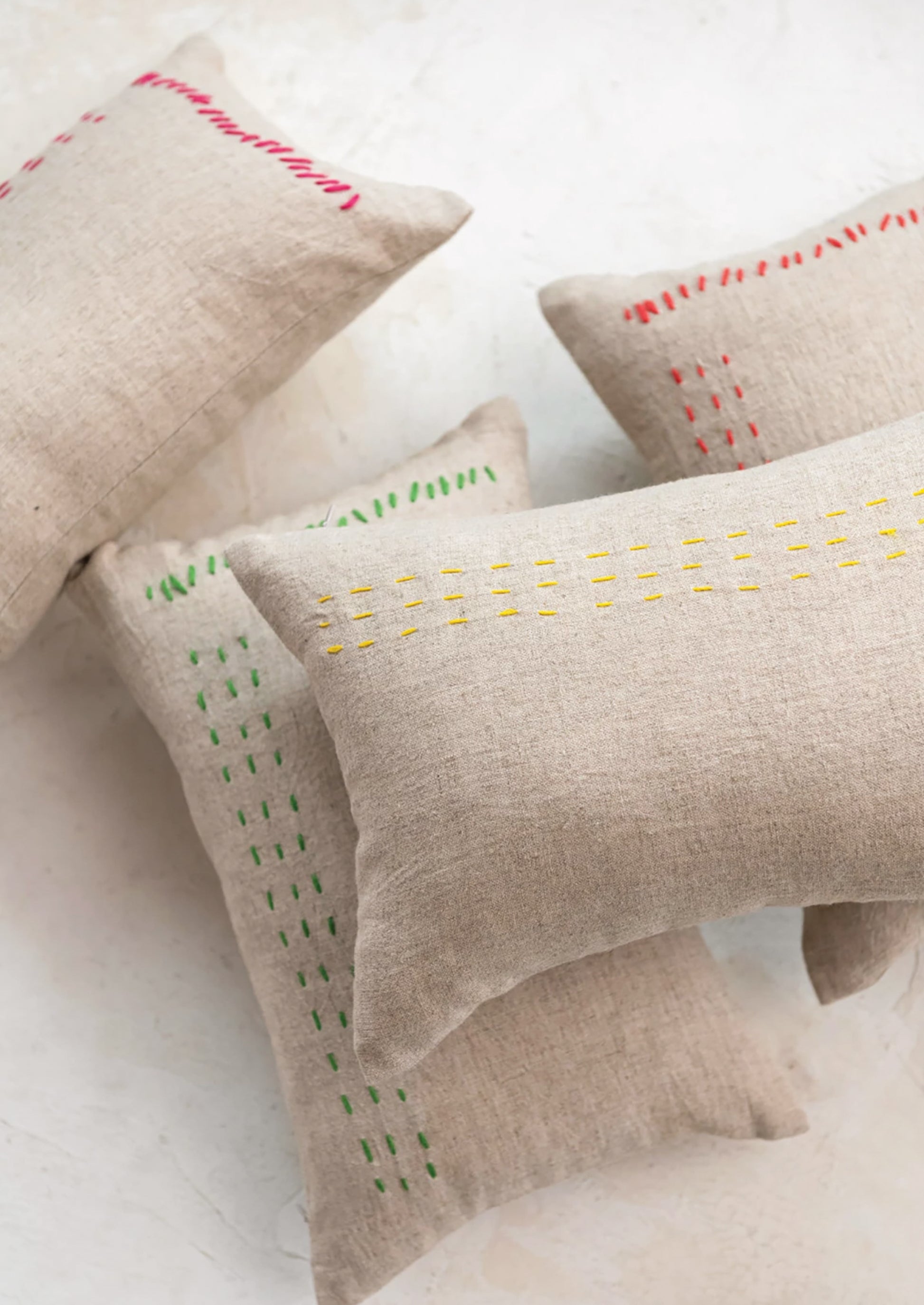 Linen lumbar pillows in natural linen with assorted color stitching detail.