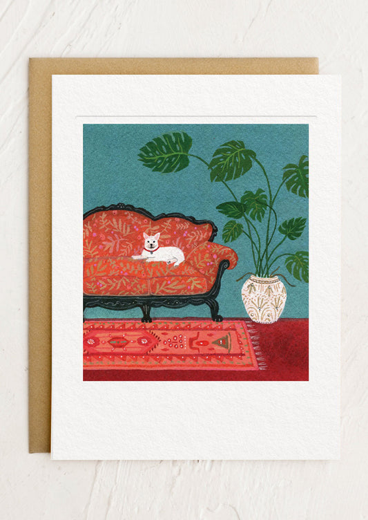 Framed artwork of a red couch with a white dog, green plant, and patterned rug on a blue background.