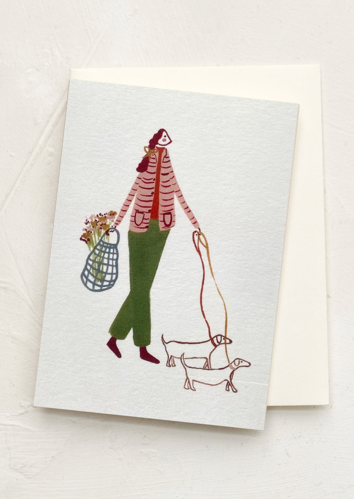 Greeting card with illustration of a person walking a dog on a white background