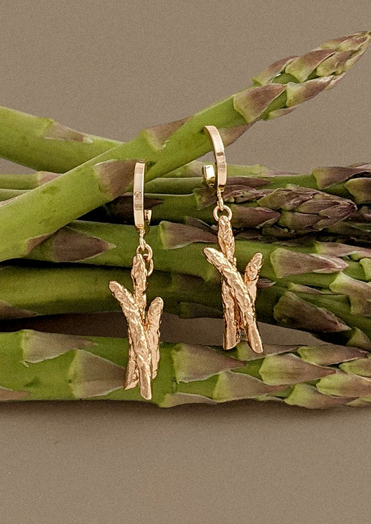 A pair of asparagus earrings in gold.