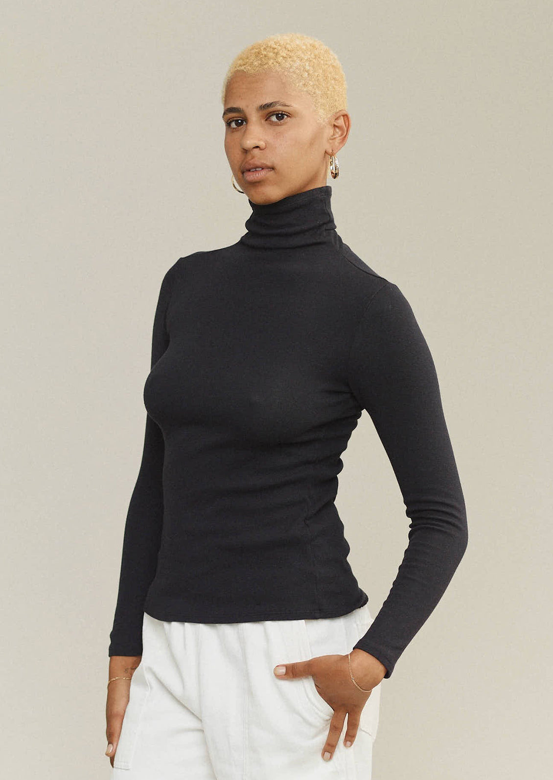 A woman wearing a turtleneck t-shirt in black.
