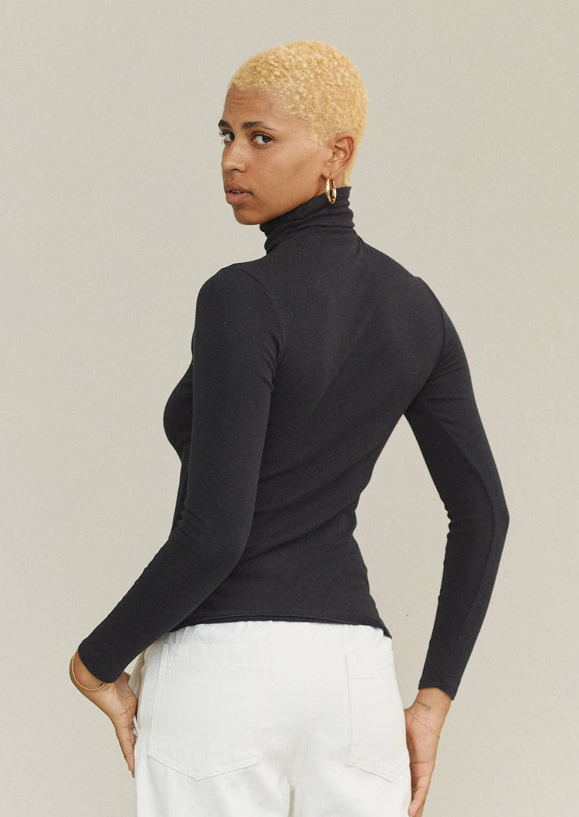 A woman wearing a turtleneck t-shirt in black.