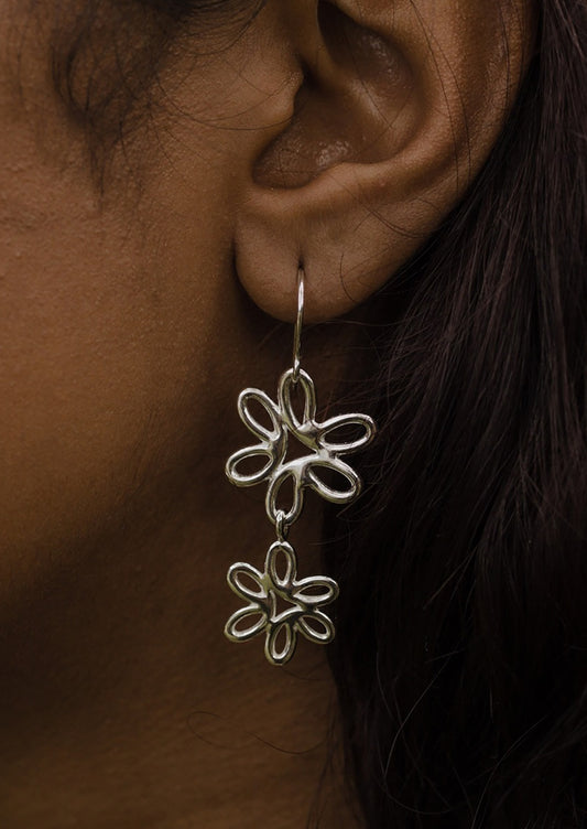 A pair of sterling silver earrings with connected double flower shape.