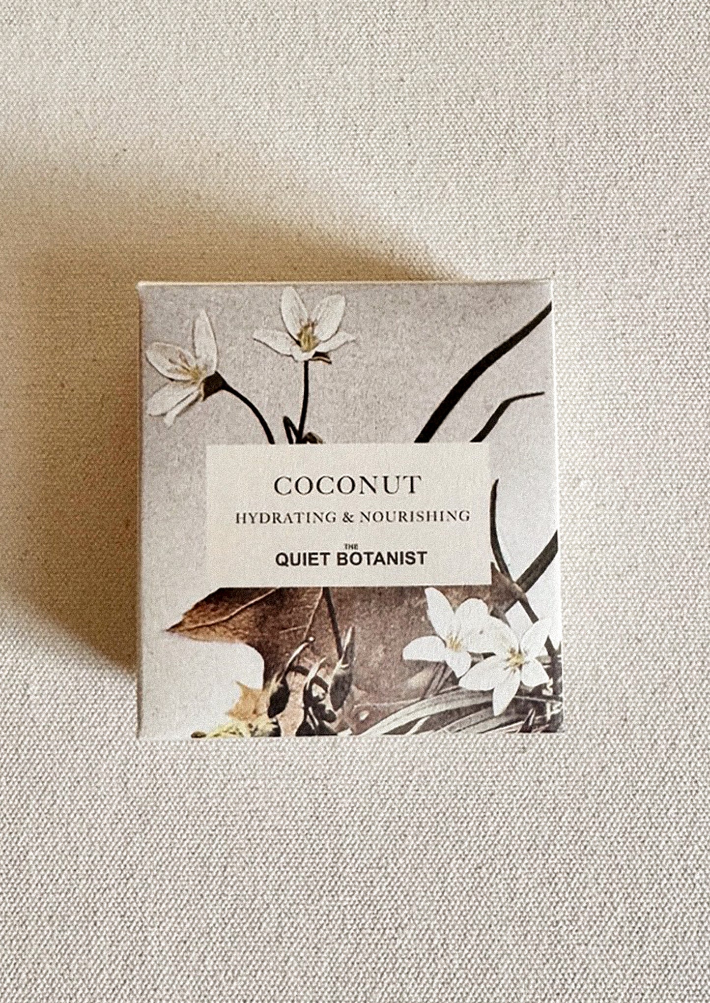 Box of Quiet Botanist coconut soap on a textured beige background.