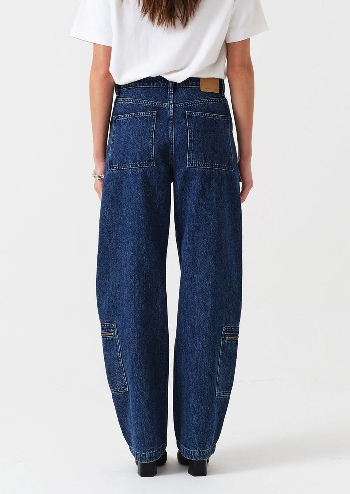 Person wearing blue jeans and a white shirt on a white background