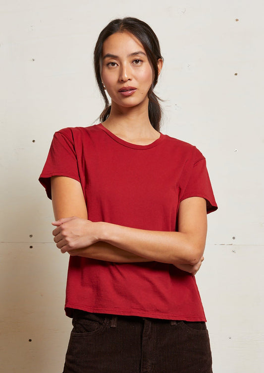 A woman wearing a short sleeve t-shirt in rich red color.