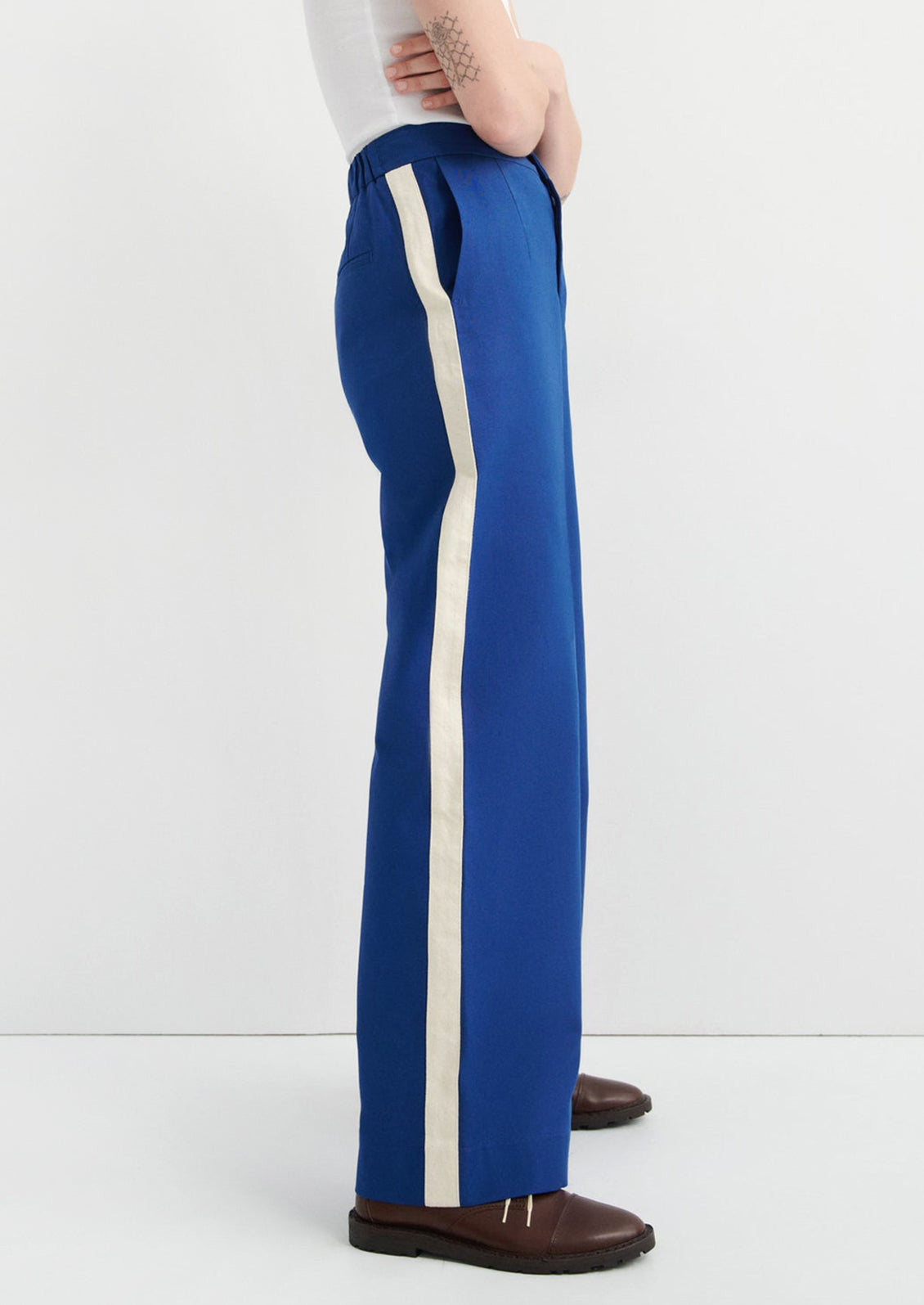 Blue pants with a white stripe worn by a person on a white background