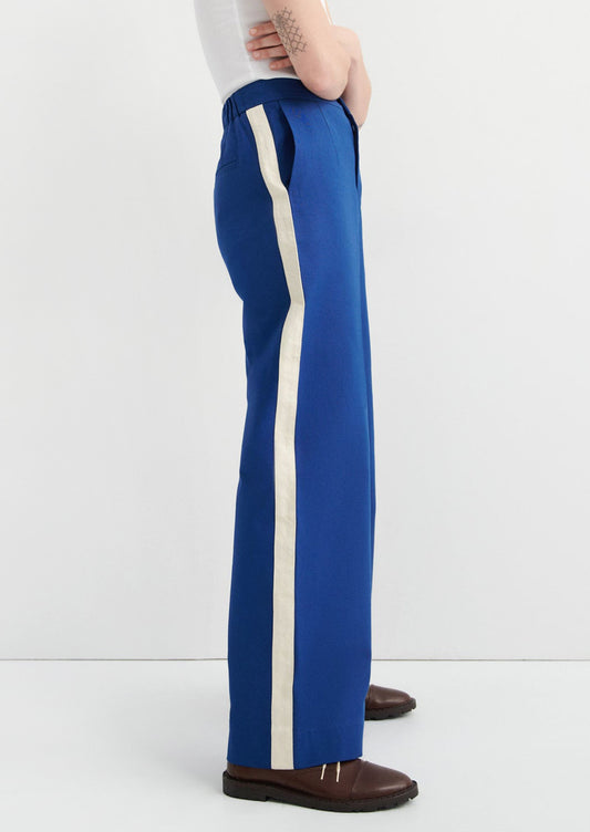 Blue pants with a white stripe worn by a person on a white background
