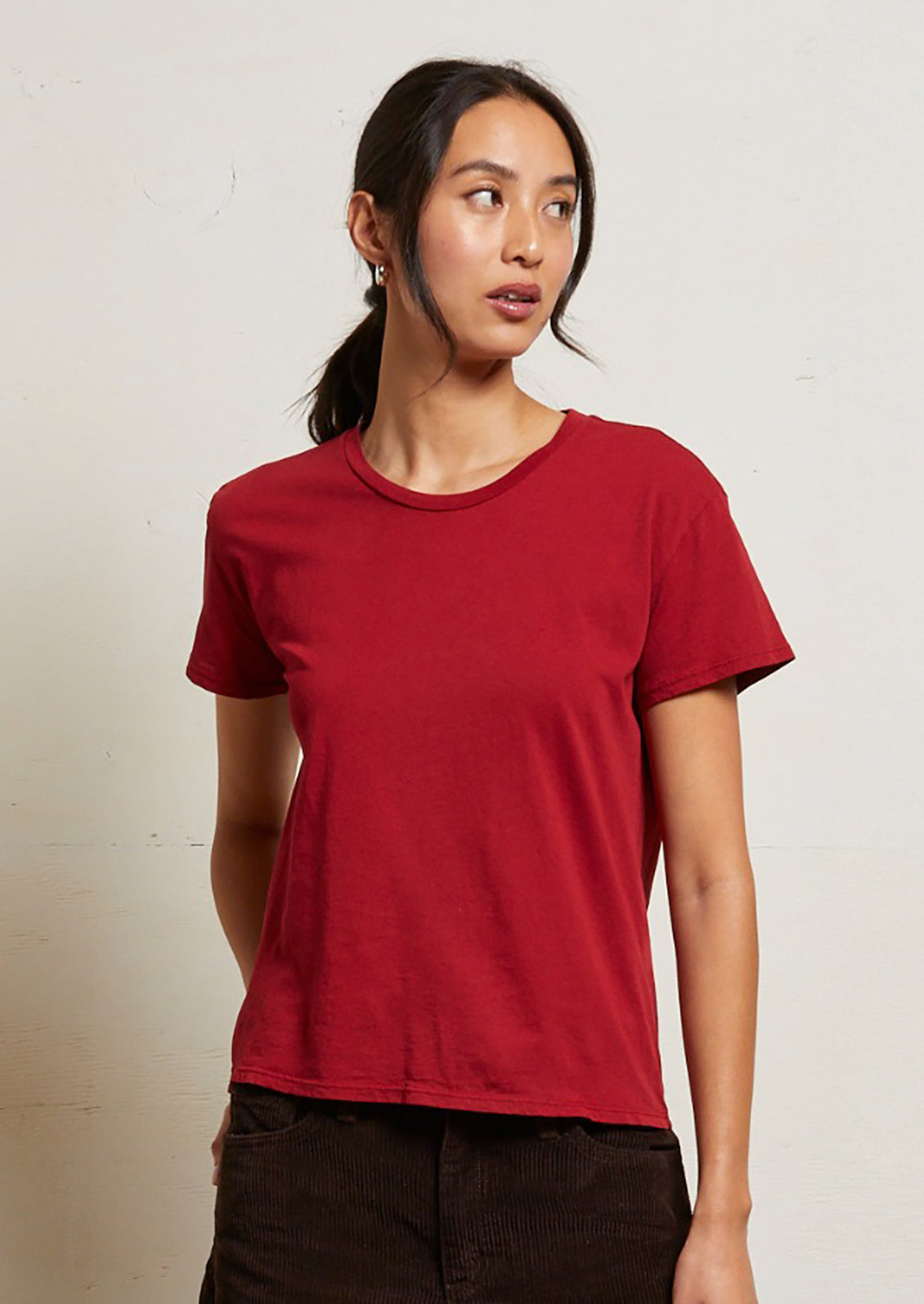 A woman wearing a short sleeve t-shirt in rich red color.